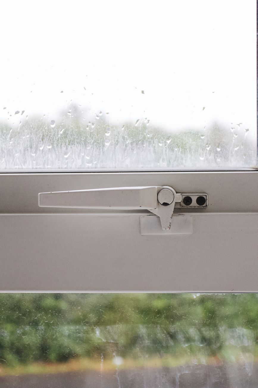 A locked window with rain on the glass